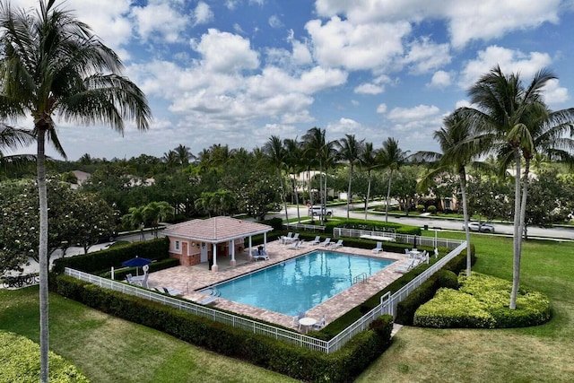 pool with a lawn, fence, and a patio area