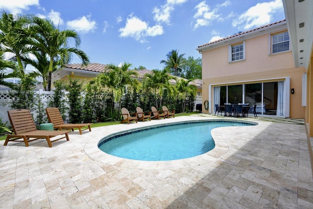 view of pool with a fenced in pool, fence, outdoor dining area, and a patio area