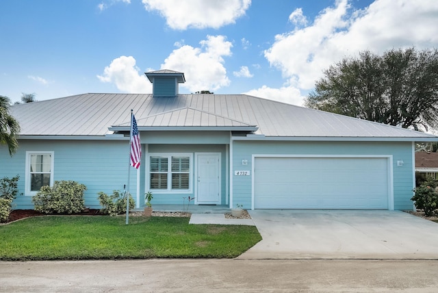 4732 SE Starling Cir, Stuart, FL 34997 - view of front of home featuring metal roof, a front lawn, driveway, and an attached garage