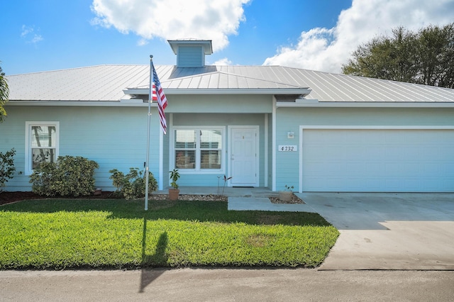 4732 SE Starling Cir, Stuart, FL 34997 - ranch-style house featuring a front lawn, a standing seam roof, metal roof, driveway, and an attached garage