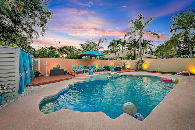 view of pool featuring fence, a wooden deck, a pool with connected hot tub, and outdoor lounge area