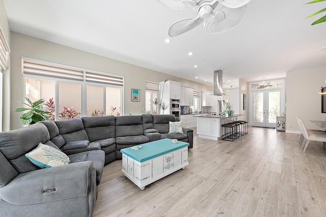 living area with a ceiling fan, french doors, recessed lighting, and light wood-style flooring