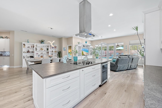 kitchen featuring wine cooler, light wood-style floors, open floor plan, and island range hood