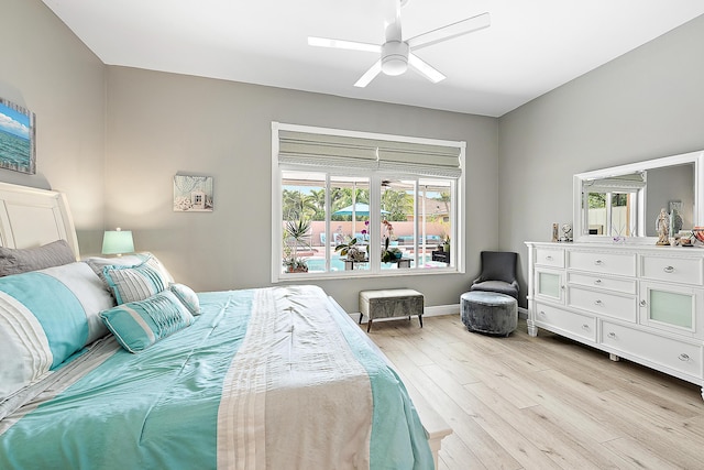bedroom featuring a ceiling fan, light wood finished floors, and multiple windows