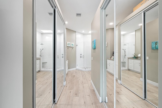 corridor with recessed lighting, baseboards, visible vents, and light wood finished floors