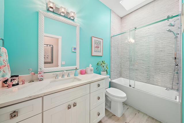 bathroom with vanity, combined bath / shower with glass door, toilet, and wood finished floors
