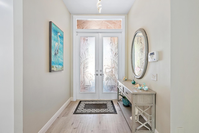 doorway with french doors, baseboards, and wood finished floors