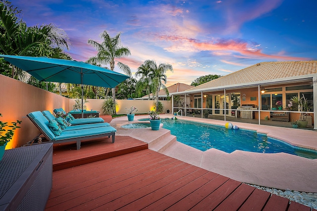 view of pool with a sunroom, a fenced backyard, a deck, and a patio area