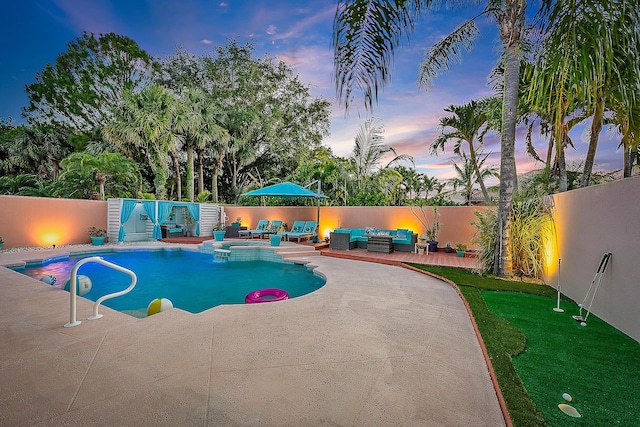 view of swimming pool featuring a fenced backyard, a pool with connected hot tub, a patio area, and outdoor lounge area