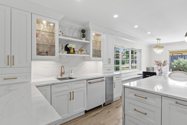 912 Roberts Rd, Delray Beach, FL 33483 - kitchen featuring a sink, white dishwasher, light wood-style flooring, hanging light fixtures, and white cabinets