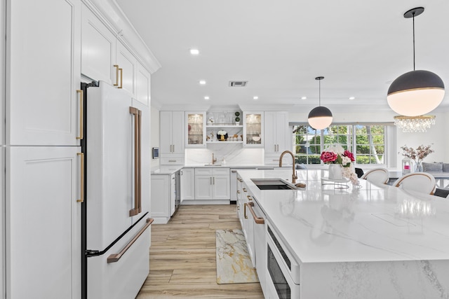 912 Roberts Rd, Delray Beach, FL 33483 - kitchen with high end white refrigerator, a sink, visible vents, a large island with sink, and white cabinets