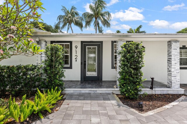 912 Roberts Rd, Delray Beach, FL 33483 - view of exterior entry with stucco siding and covered porch