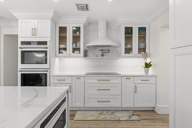 912 Roberts Rd, Delray Beach, FL 33483 - kitchen with visible vents, white cabinets, wall chimney range hood, and white double oven