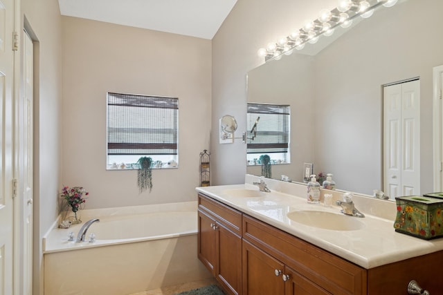full bath with a healthy amount of sunlight, a garden tub, and a sink
