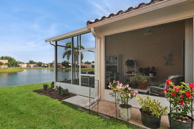 exterior space with stucco siding, a water view, and a lawn