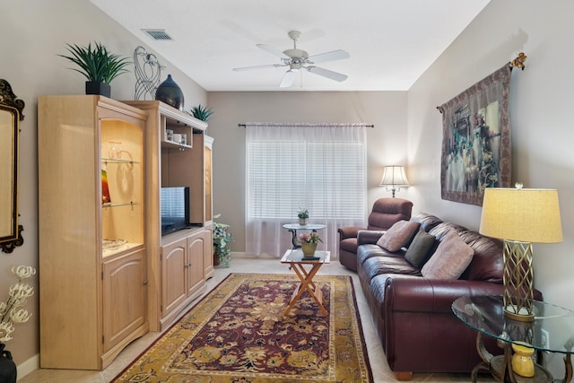 living area featuring baseboards, visible vents, and a ceiling fan