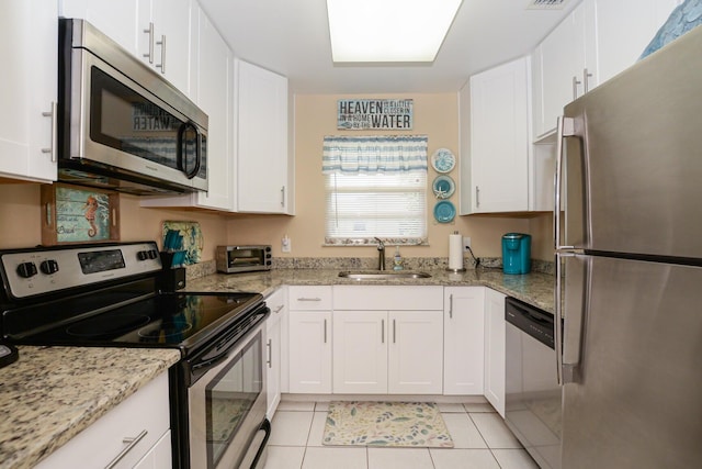 13 Lake Vista Trl Unit 202, Port Saint Lucie, FL 34952 - kitchen featuring light tile patterned flooring, stainless steel appliances, white cabinets, and a sink
