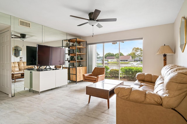 living area featuring ceiling fan and visible vents