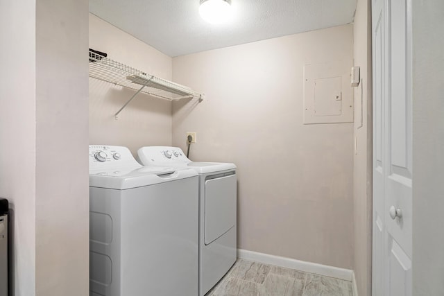laundry area featuring laundry area, washer and clothes dryer, baseboards, and electric panel