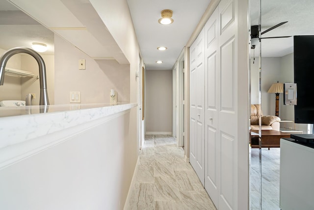 hall featuring recessed lighting, baseboards, and marble finish floor