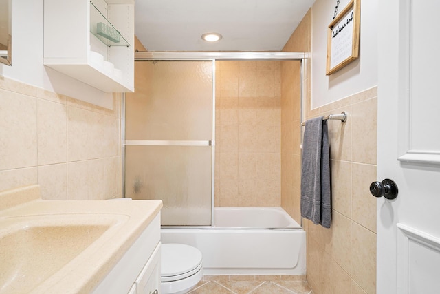 bathroom with vanity, toilet, shower / bath combination with glass door, tile walls, and recessed lighting