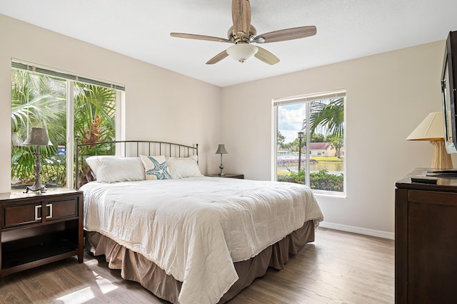 bedroom featuring baseboards, ceiling fan, and wood finished floors