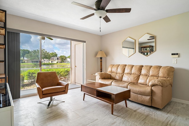 living room with baseboards and ceiling fan