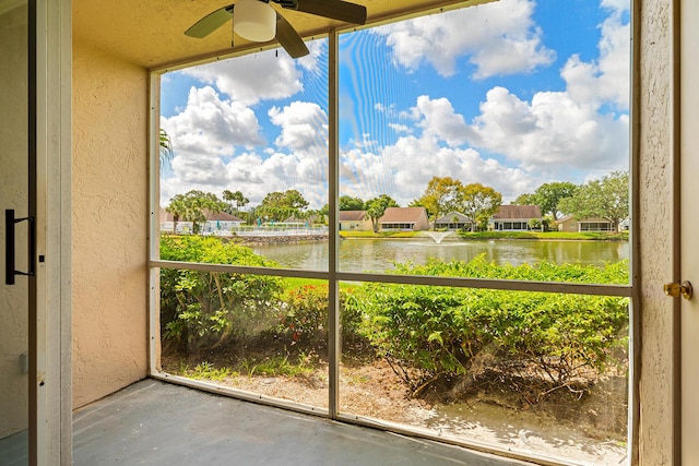 unfurnished sunroom with a water view, plenty of natural light, and a ceiling fan