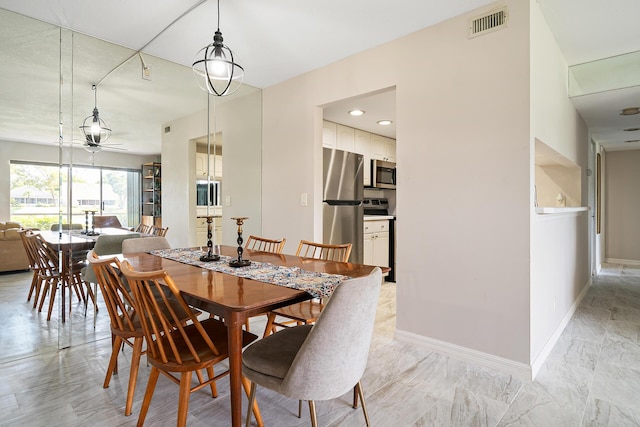 dining room with baseboards, ceiling fan, and visible vents