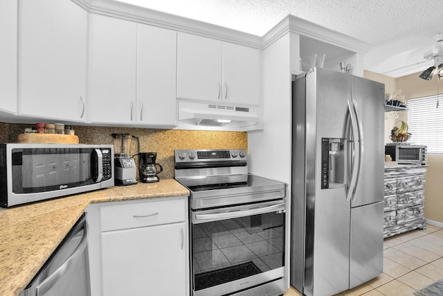 136 Centennial Ct, Deerfield Beach, FL 33442 - kitchen featuring under cabinet range hood, stainless steel appliances, light countertops, light tile patterned floors, and white cabinetry
