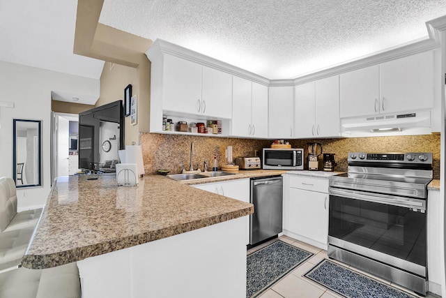 136 Centennial Ct, Deerfield Beach, FL 33442 - kitchen featuring stainless steel appliances, a peninsula, a sink, backsplash, and under cabinet range hood