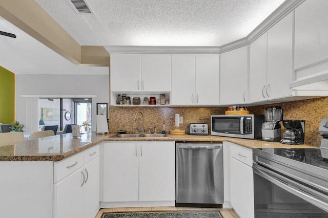 136 Centennial Ct, Deerfield Beach, FL 33442 - kitchen featuring stainless steel appliances, a peninsula, a sink, tasteful backsplash, and visible vents