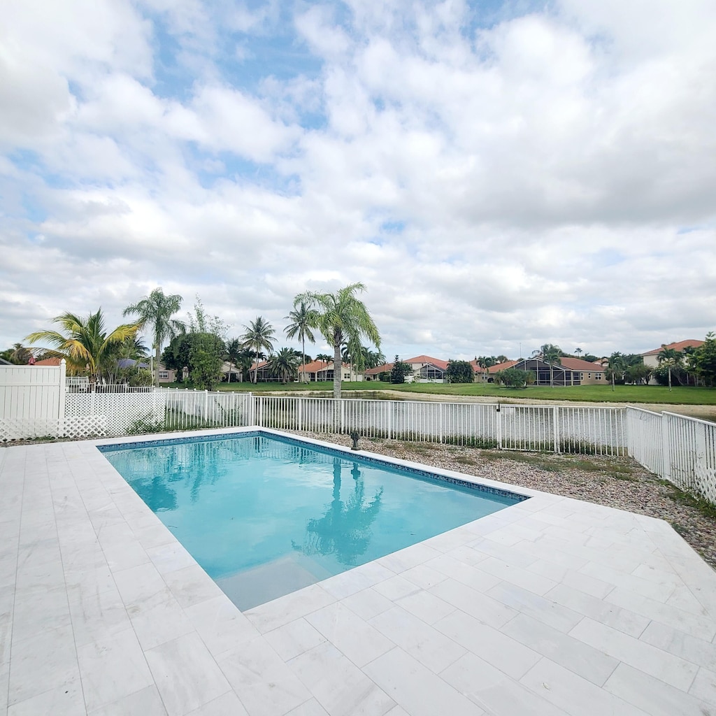 view of swimming pool featuring a fenced in pool, a fenced backyard, a patio area, and a residential view