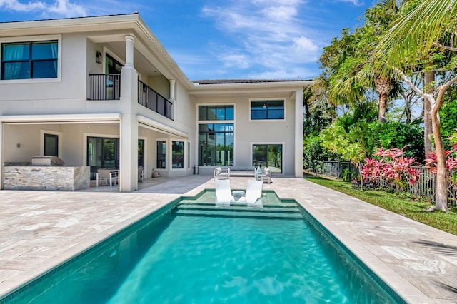 7015 NW 27th Ave, Boca Raton, FL 33496 - rear view of house with stucco siding, a patio area, a balcony, and an outdoor kitchen
