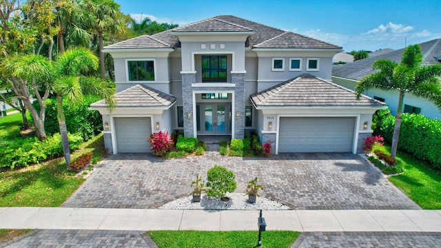 7015 NW 27th Ave, Boca Raton, FL 33496 - mediterranean / spanish home with stucco siding, decorative driveway, french doors, and an attached garage