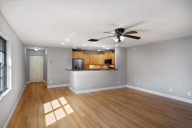 unfurnished living room with baseboards, recessed lighting, ceiling fan, and light wood-style flooring