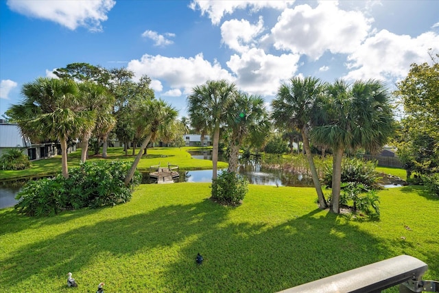 surrounding community with a yard and a water view
