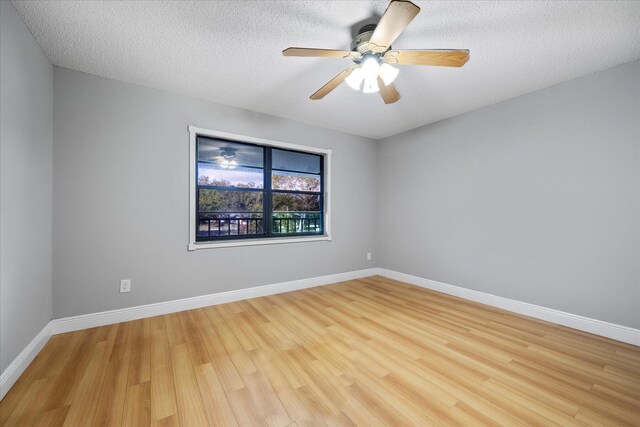 empty room with a textured ceiling, ceiling fan, baseboards, and light wood-style floors