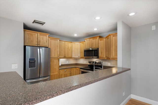 kitchen featuring recessed lighting, appliances with stainless steel finishes, baseboards, visible vents, and a peninsula