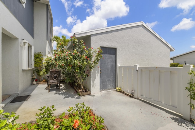 exterior space featuring fence, a patio area, and stucco siding