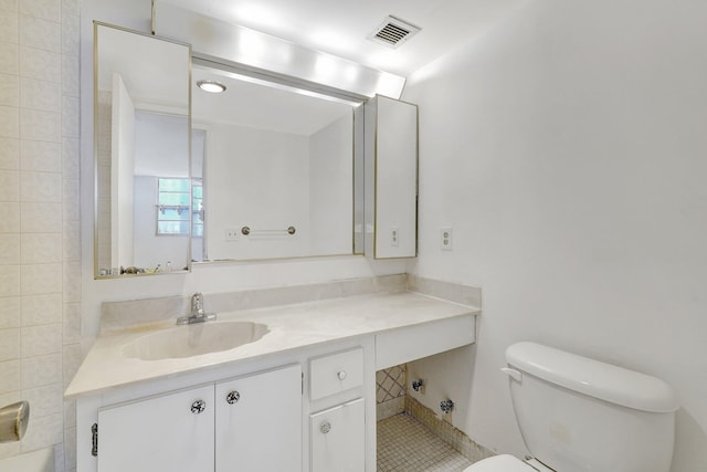 bathroom with toilet, tile patterned flooring, visible vents, and vanity