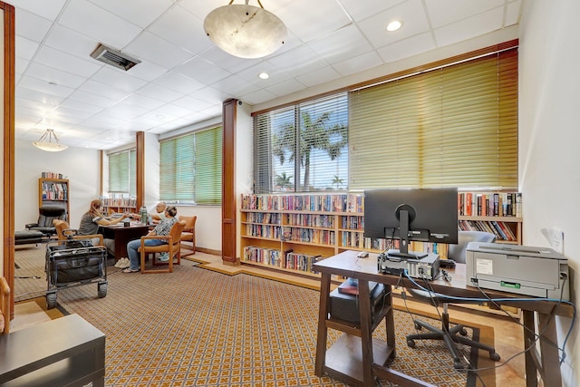 office area featuring baseboards, visible vents, carpet floors, and a paneled ceiling