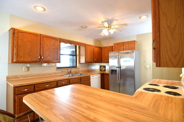 kitchen featuring butcher block counters, dishwasher, stainless steel refrigerator with ice dispenser, and a sink