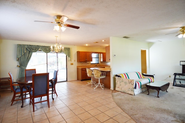 dining space with ceiling fan with notable chandelier, visible vents, a wealth of natural light, and light tile patterned flooring