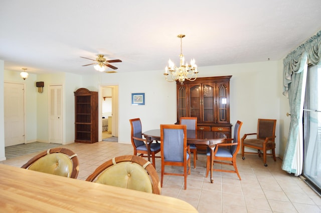 dining area featuring light tile patterned floors and ceiling fan with notable chandelier
