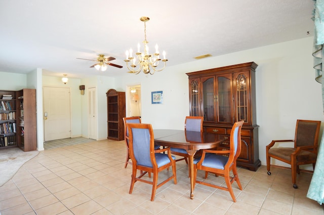dining space with ceiling fan with notable chandelier, visible vents, and light tile patterned floors