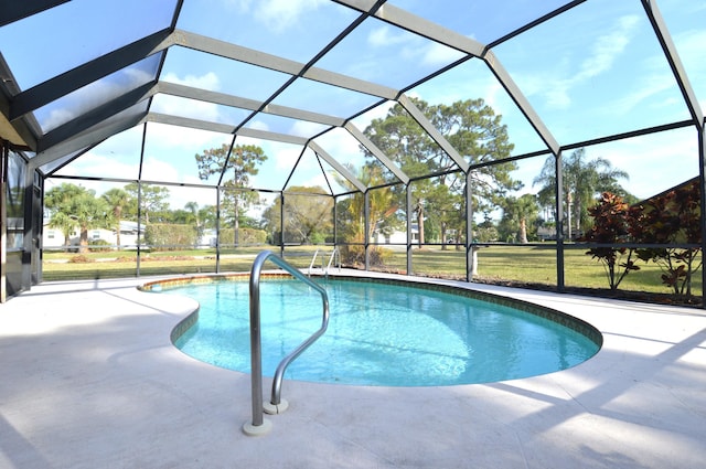 outdoor pool with a lawn, a patio area, and a lanai