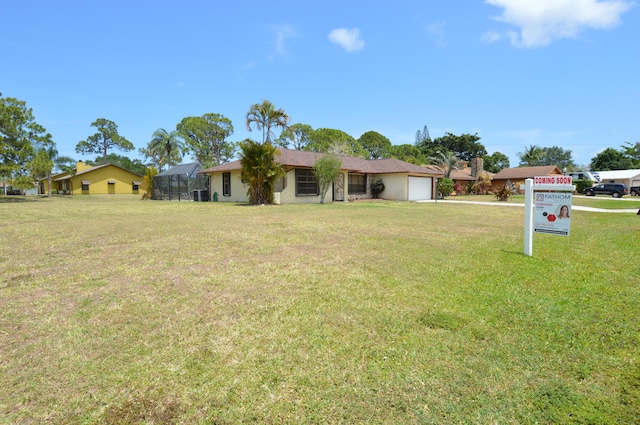 ranch-style home featuring a front lawn, glass enclosure, and a garage