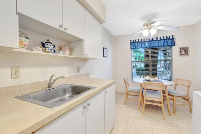 kitchen with a sink, open shelves, white cabinets, and light countertops