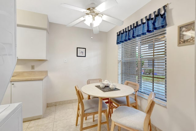 dining space featuring baseboards, ceiling fan, and light tile patterned floors
